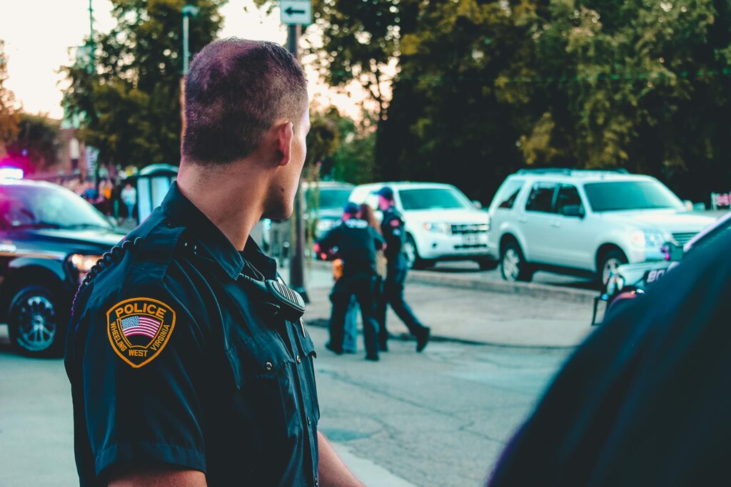 Police officer monitoring a street scene with patrol vehicles in Wheeling, WV.